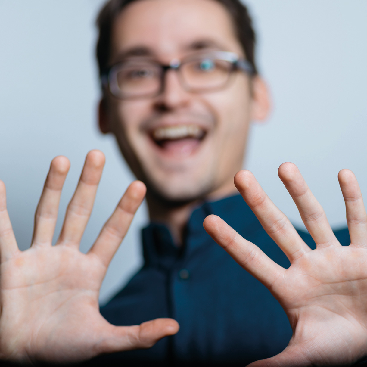 Mann zeigt 10 Finger in die Kamera
