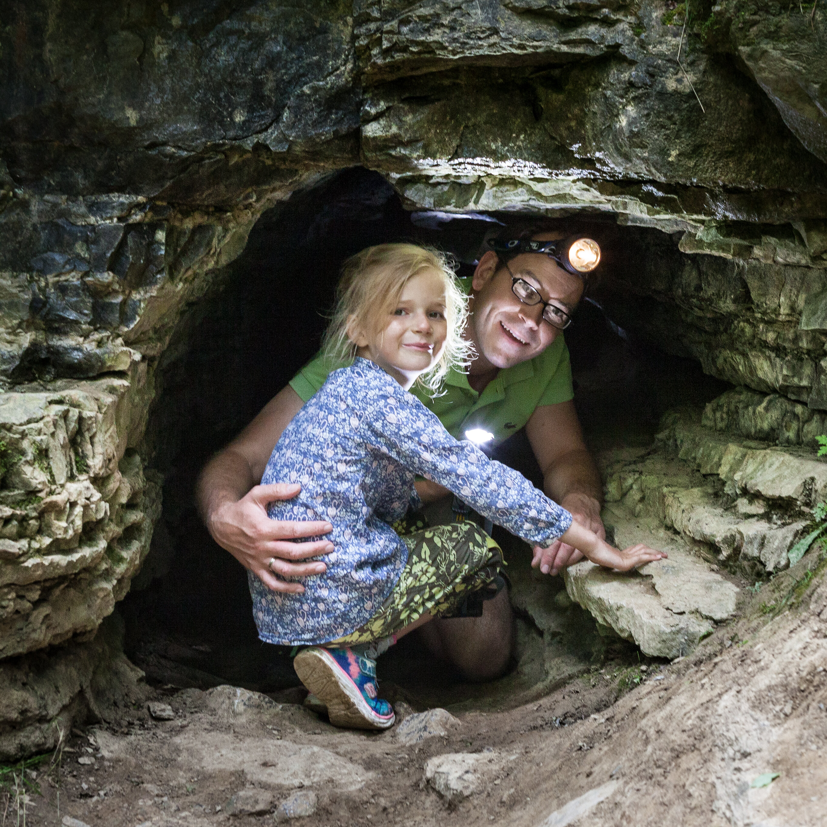 Kind und Mann mit Stirnlampe in der Sieben-Täler-Höhle