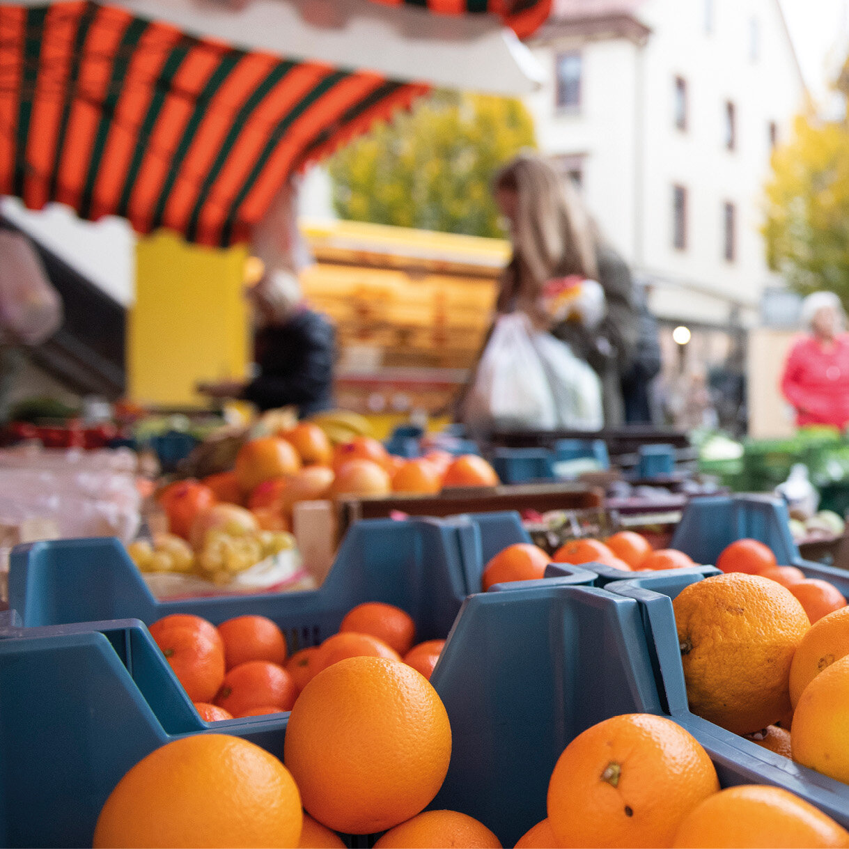 Mehrere Kisten mit Orangen auf einem Marktstand