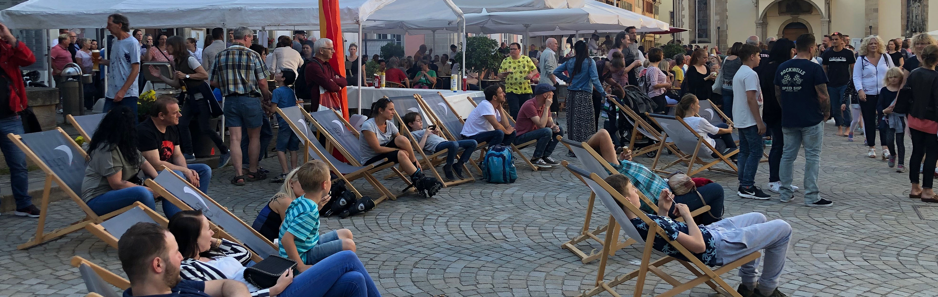 Menschen in Liegestühlen auf dem Marktplatz